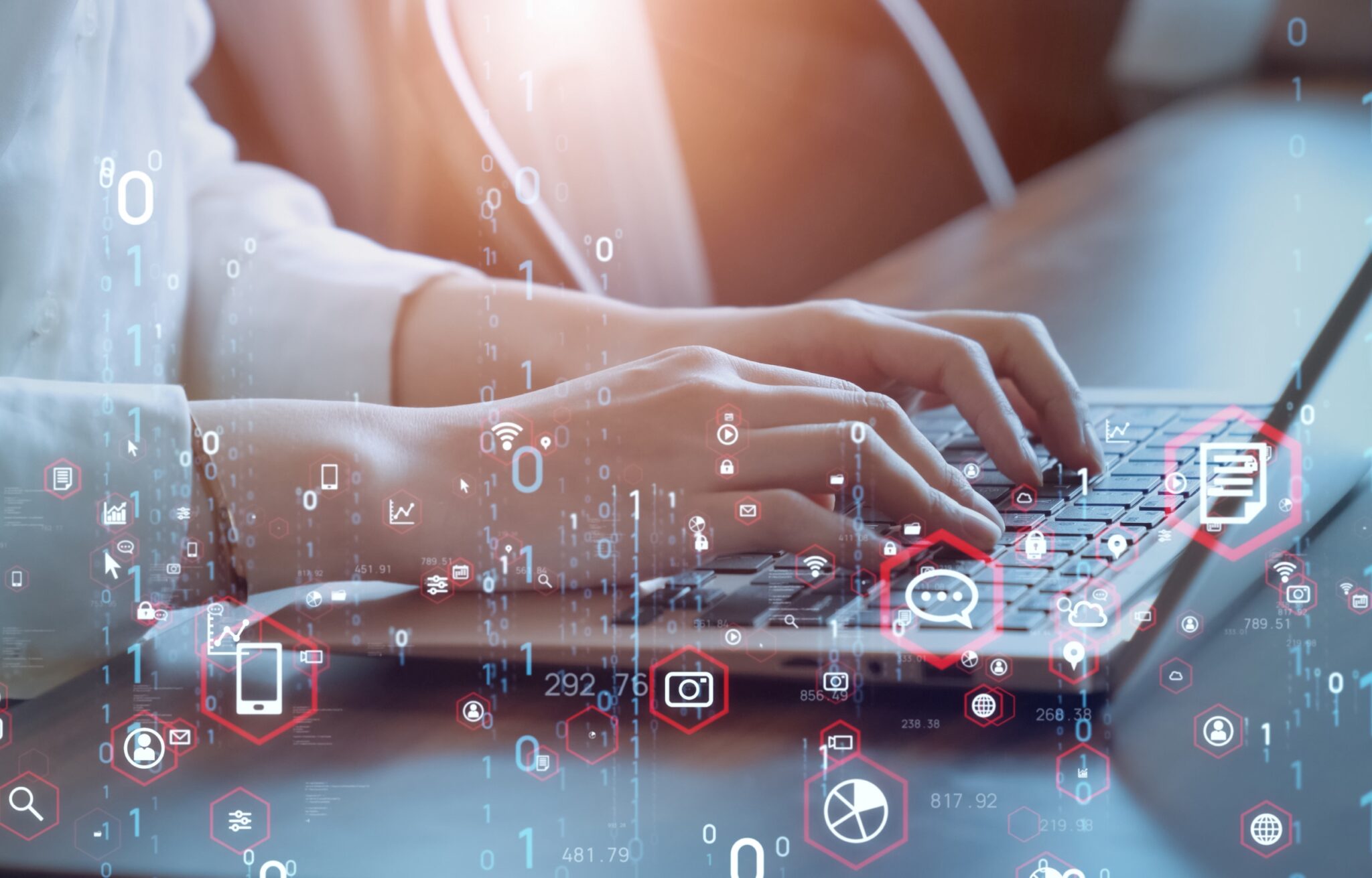 Person tippt auf Laptoptastatur. Interaktive Symbole werden im Vordergrund schwebend angezeigt.